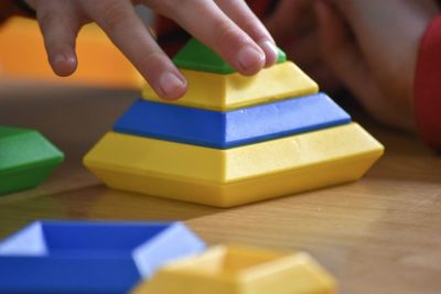 Close-up of hand playing with toy on table