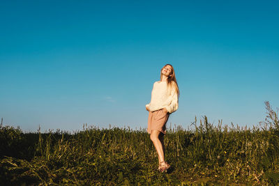 Woman standing on field against clear sky