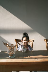 Portrait of smiling girl on table