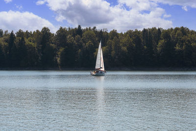 Sailboat sailing on lake against sky