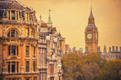 Big ben by buildings against sky in city