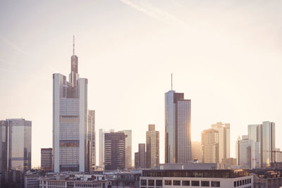 Modern buildings against sky in city during sunset