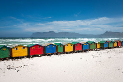 Multi colored umbrellas on beach against blue sky