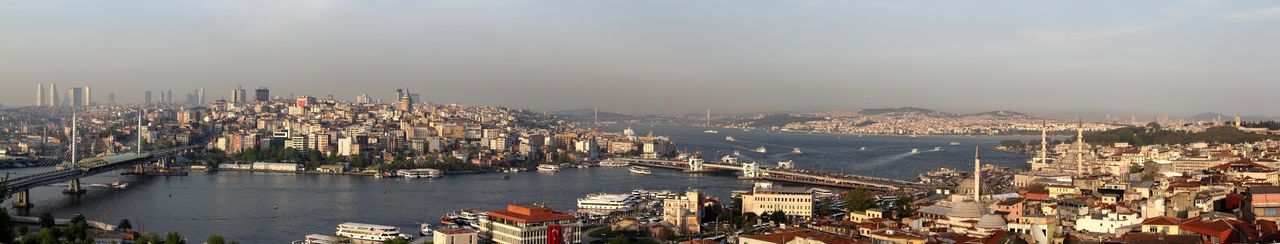 High angle view of city by sea against sky