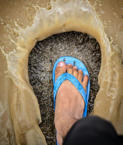 Low section of man stamping foot in puddle