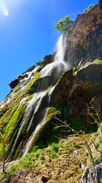 Low angle view of waterfall against sky
