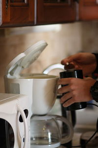 Midsection of man holding coffee cup