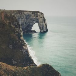 Rock formation in sea against sky