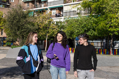 Young diverse friends walking outdoors on the street.