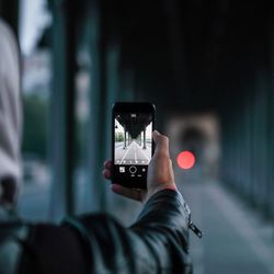 Midsection of person photographing in mobile phone