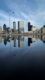 Reflection of buildings in a puddle  against sky