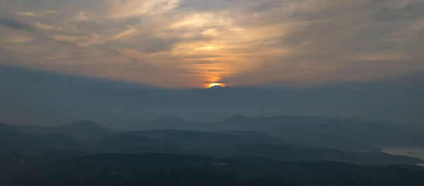 Scenic view of silhouette mountains against sky at sunset