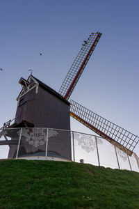 Low angle view of windmill on field against clear sky