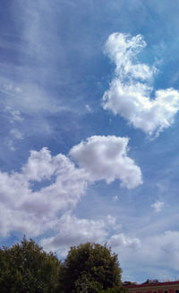 Low angle view of trees against blue sky