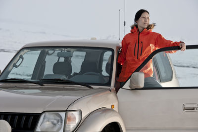 Woman standing in the door of her suv in iceland