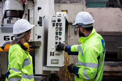 Engineers operating machinery in factory