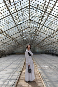 Rear view of woman walking in greenhouse 