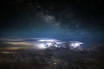 Aerial view of illuminated buildings against sky at night