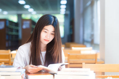 Portrait of young woman reading book