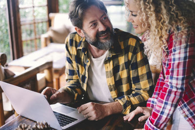 Midsection of woman using laptop while sitting at home