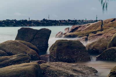 Rocks on beach against sky