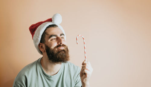 Man looking at candy cane against wall