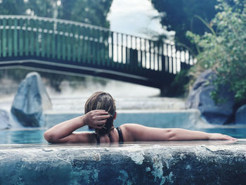 Portrait of young woman sitting in swimming pool