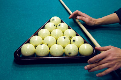 White balls for billiards in a triangle and hands of men and with the cue
