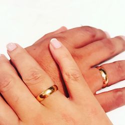 Close-up of couple holding hands over white background