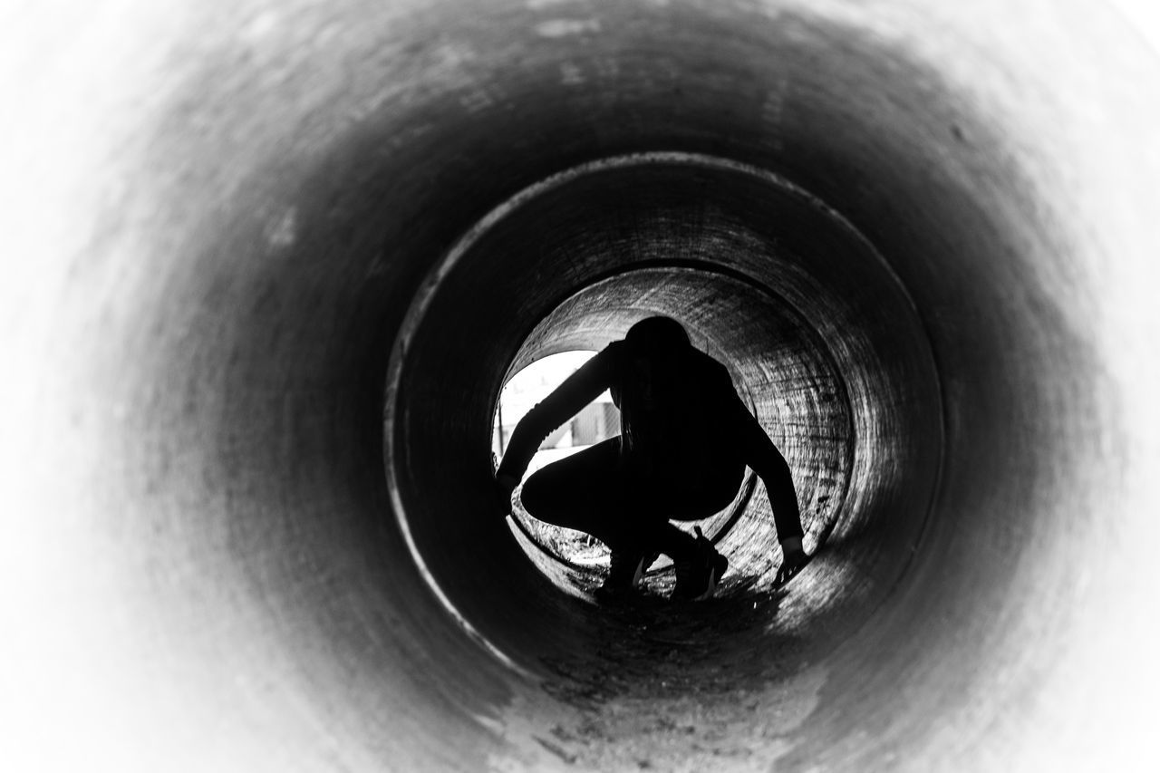 HIGH ANGLE VIEW OF MAN IN TUNNEL AT DUSK