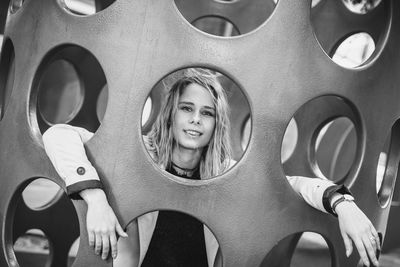 Portrait of young woman in play equipment at playground