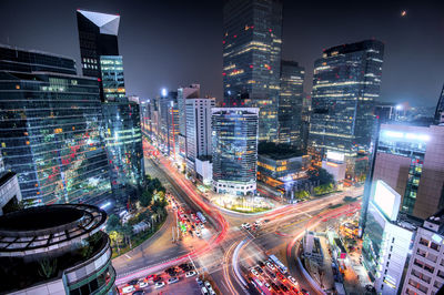 High angle view of illuminated city street and buildings at night