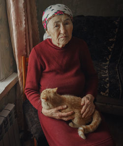 Portrait of old woman holding cat