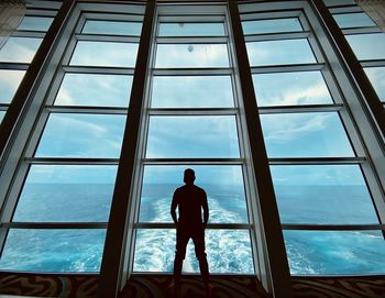 Rear view of man standing in glass window