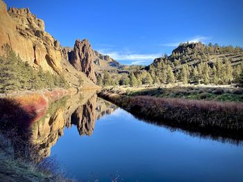 Scenic view of lake and mountains against blue sky