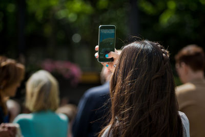 Rear view of woman photographing