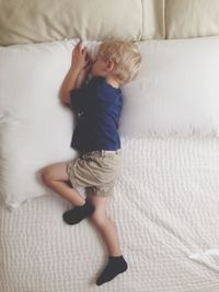 High angle view of boy sleeping on bed