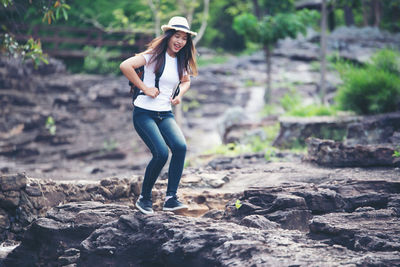 Portrait of young woman standing on rock