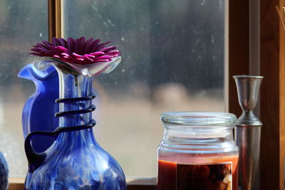 Close-up of flower in vase on window sill