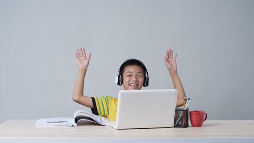 Portrait of man using mobile phone while sitting on table