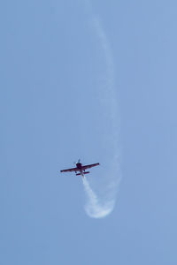 Low angle view of airplane against clear blue sky