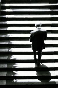 Rear view of man walking on zebra crossing