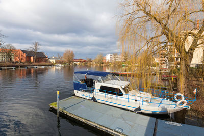 Boats moored on river against sky