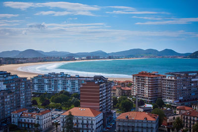 High angle view of city by sea against sky