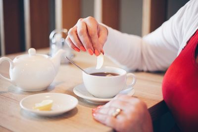 Cropped image of woman having coffee in cafe