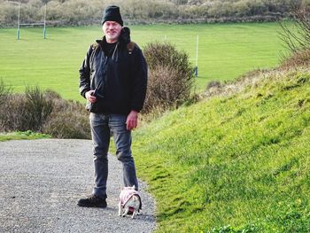 Portrait of man with puppy standing on road