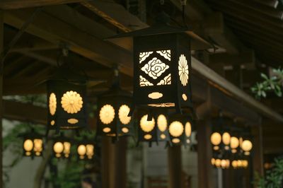 Low angle view of illuminated lanterns hanging in building