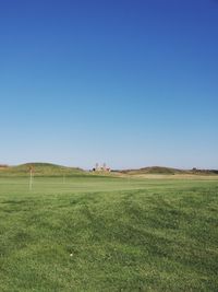 Scenic view of field against clear blue sky