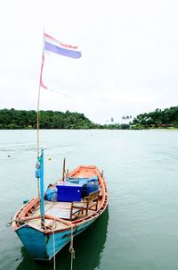 Boat moored on sea against sky