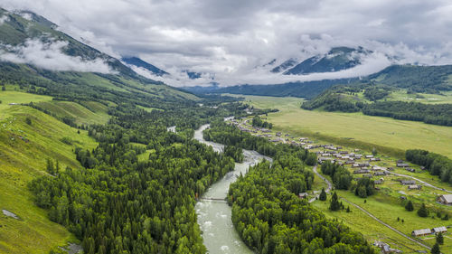 High angle view of road amidst trees against sky